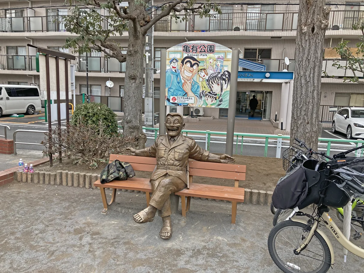 両さんの銅像がベンチに座っています。亀有公園。